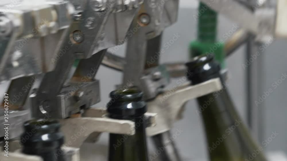 Glass bottles on the automatic conveyor line at the champagne or wine factory. Plant for bottling alcoholic beverages. Glass bottles on the automatic conveyor line at the champagne or wine factory. Plant for bottling alcoholic beverages.