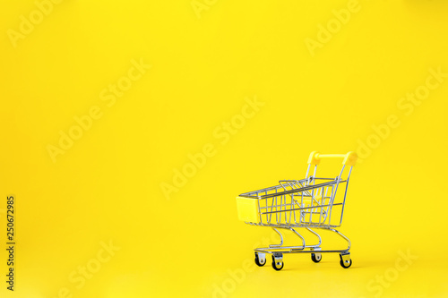 Shopping cart trolley basket is empty on a bright yellow background. Conception Festive Sale Discount. Trading Supermarket Retail.Copy space .
