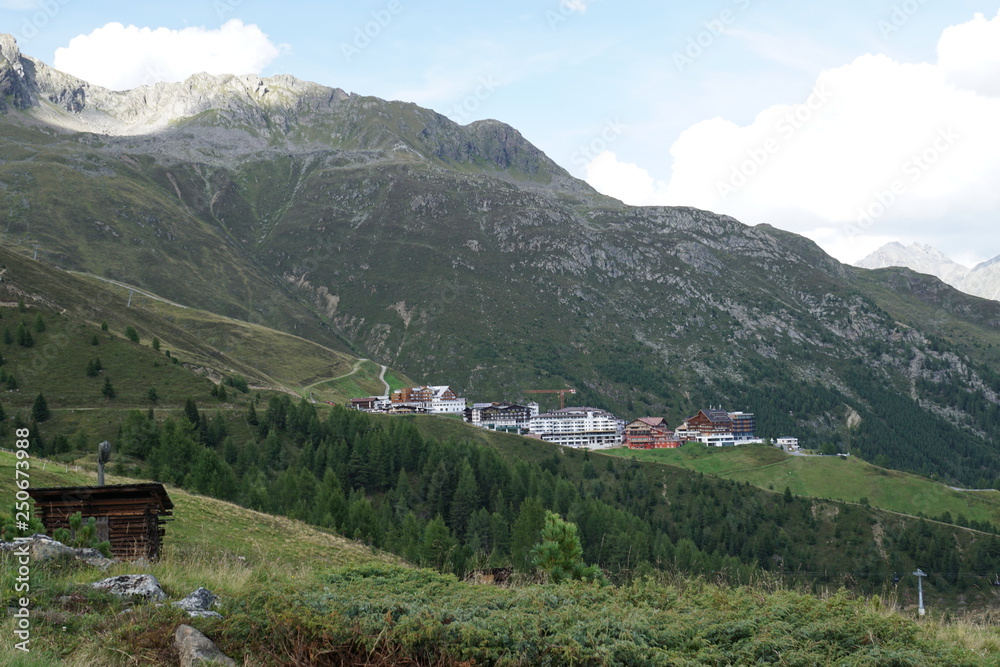 Hochsölden Berglandschaft mit Wolken, Grün, Pflanzen, Felsen und Schnee in Sölden/ Ötztal 