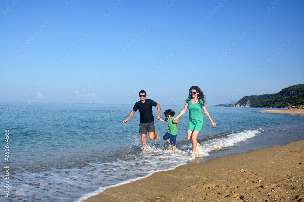 Happy family enjoying on beach. Summer vacation, family with one child having fun and run on beach