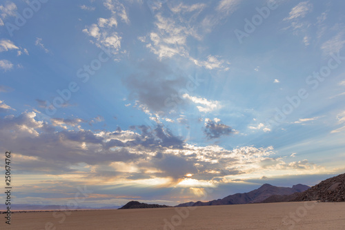 Sun behind clouds at sunrise in the desert