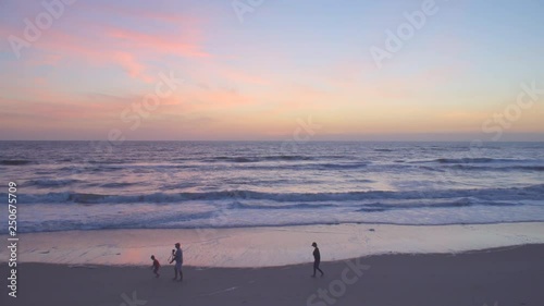 People Walking on Sandy Beach Shore at Sunset