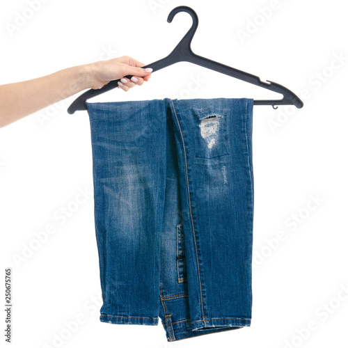 Blue jeans on hanger in hand on white background isolation photo