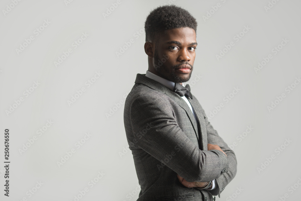 Obraz premium handsome stylish african man in a suit on a gray background