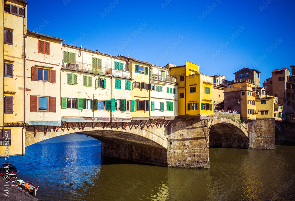 Beautiful view of  Arno River and stone medieval bridge Ponte Vecchio with of colorful houses. Famous landmark, Florence, Firenze, Tuscany, Italy.