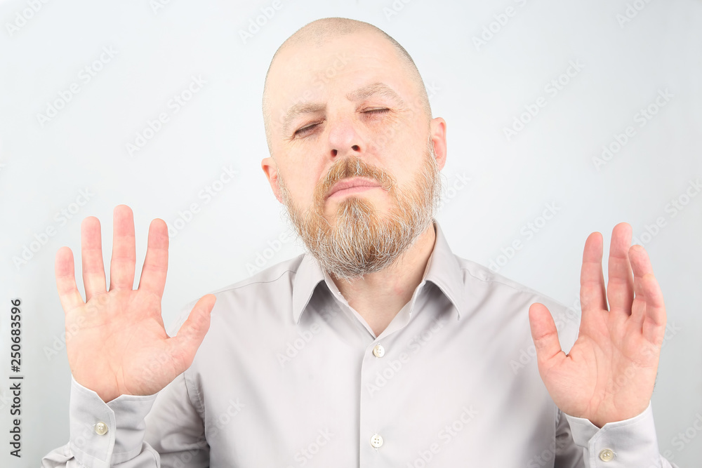 bearded man in shirt stands with his eyes closed bearded man in shirt stands with his eyes closed