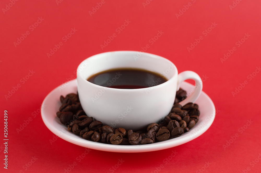 Americano black coffee in white ceramic cup with coffee grains on a saucer. Red background. front view Americano black coffee in white ceramic cup with coffee grains on a saucer. Red background. front view