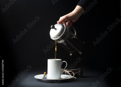 Woman's hand pouring coffee into mug