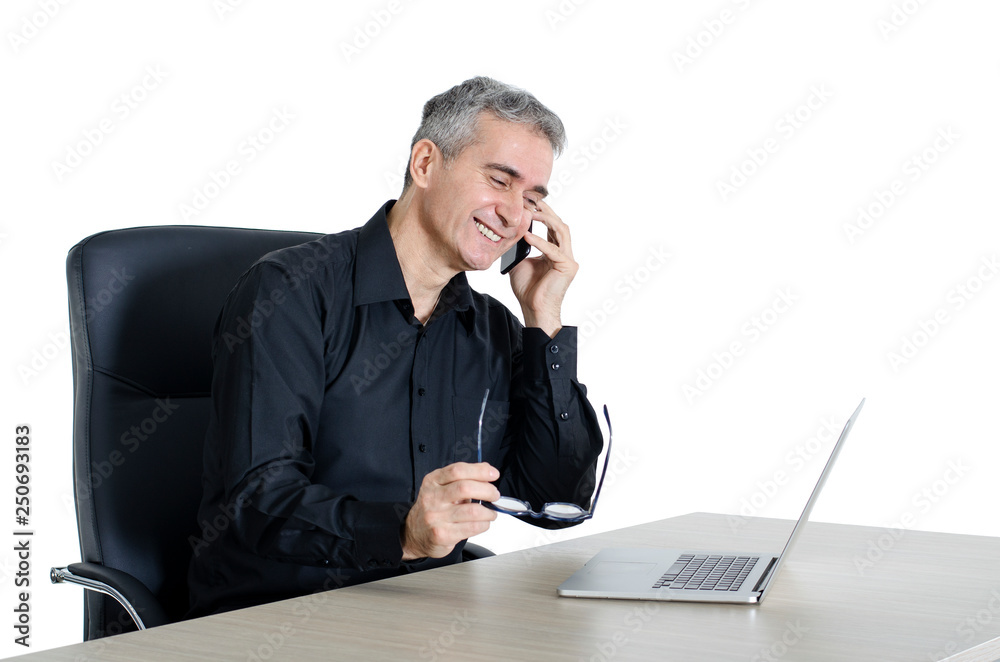 Senior businessman at his office, smiling while making friendly phone call Senior businessman at his office, smiling while making friendly phone call
