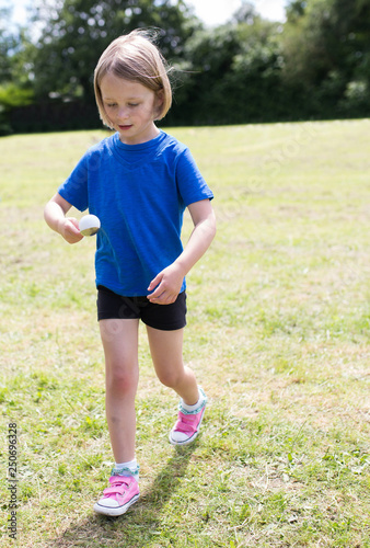 school girl doing the egg and spoon race on sports day