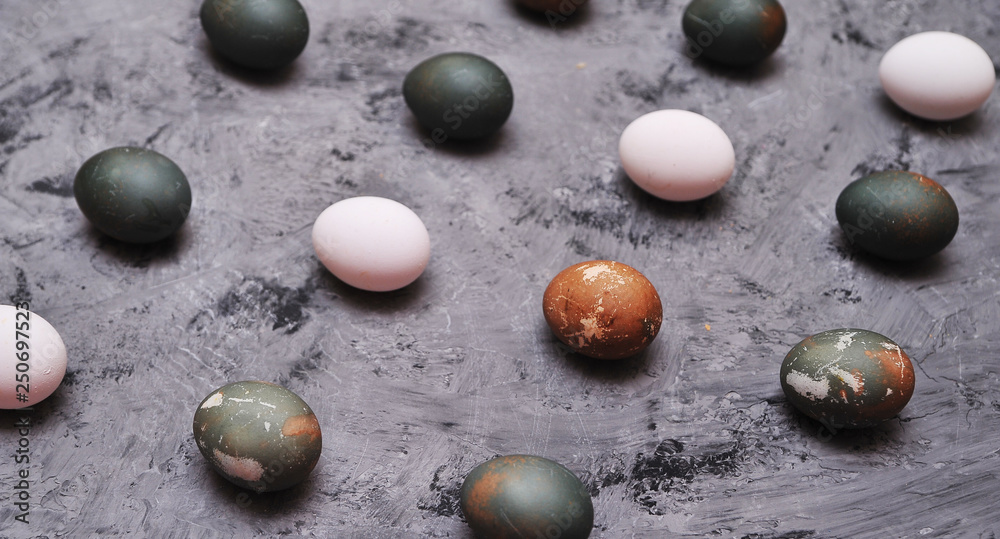 Chicken painted eggs in box on stone background.