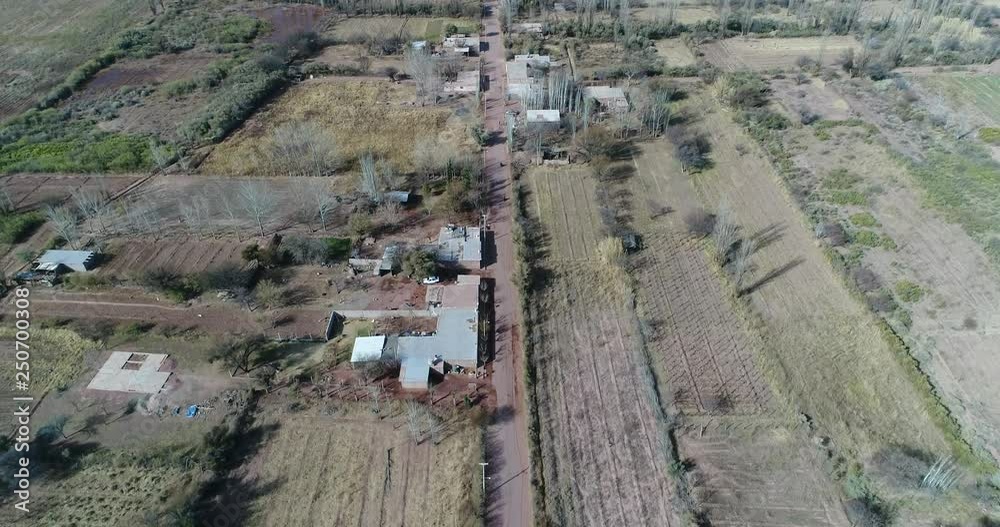 Aerial drone scene of rural landscape with little crops. Camera moving fowards at high altitude following gravel road, top view. Villa Union, Rioja province, Argentina Aerial drone scene of rural landscape with little crops. Camera moving fowards at high altitude following gravel road, top view. Villa Union, Rioja province, Argentina