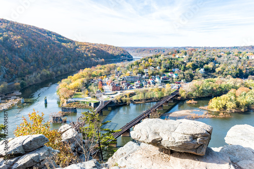 Harper's Ferry overlook with colorful orange yellow foliage during fall, autumn forest with small village town by river in West Virginia, WV photo