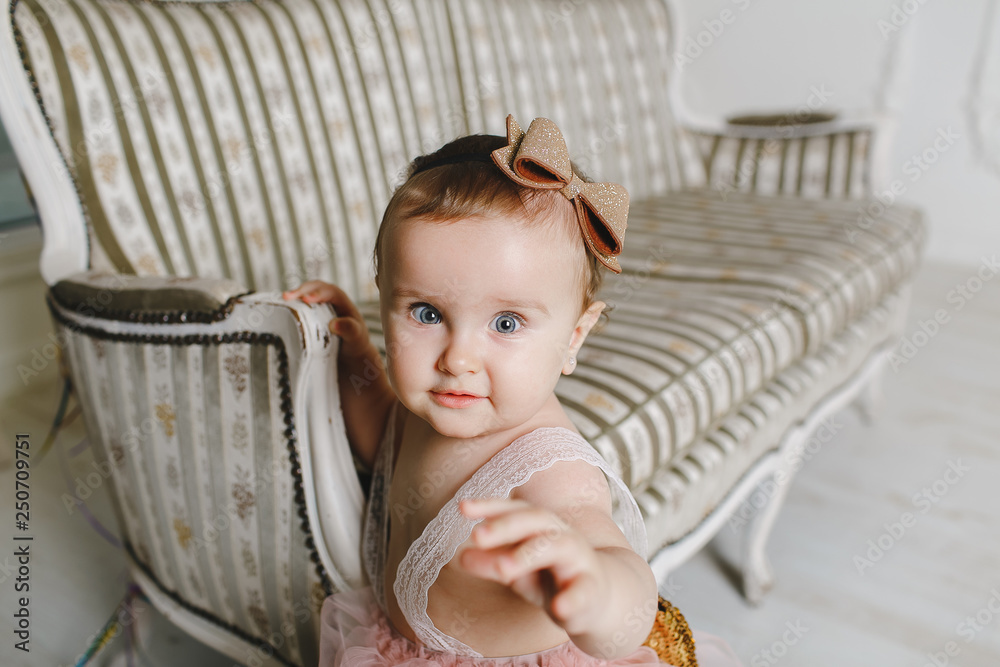 Fototapeta premium Happy little girl and beautiful next to a couch.