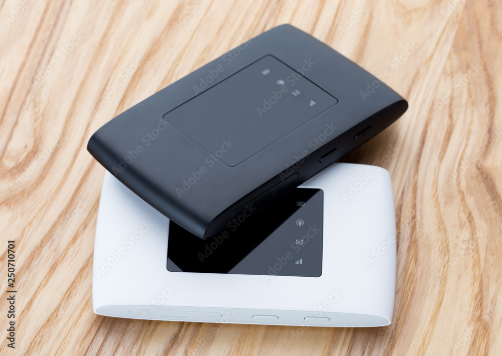 Two portable routers on the table. 4g routers on a wooden surface. Two portable routers on the table. 4g routers on a wooden surface.