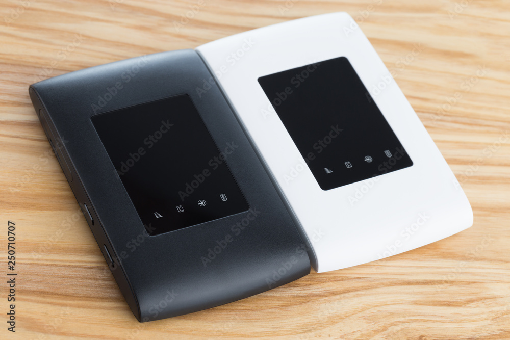 Two portable routers on the table. 4g routers on a wooden surface. Two portable routers on the table. 4g routers on a wooden surface.