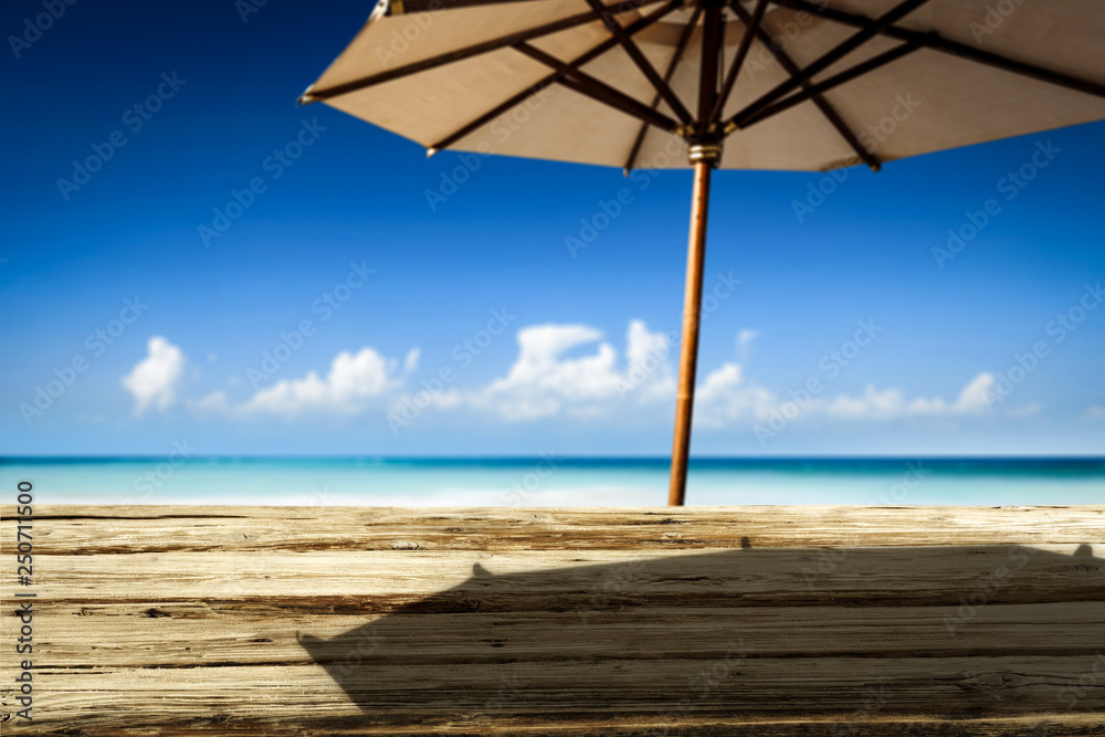 Desk of free space on beach and umbrella with shadow 