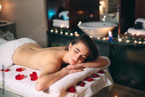 Spa, massage. A young dark-haired beautiful girl is waiting for a massage.