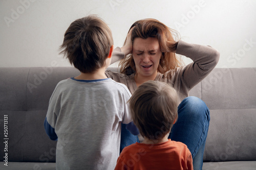  Woman mom is tired in depression and children are boys.