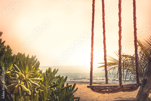 Travel lifestyle beach swing sea sunset palm trees sunlight island background vintage style copy space