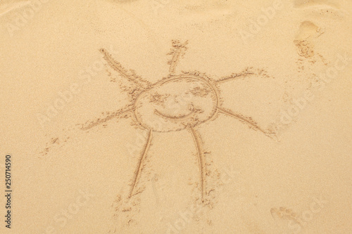 Kid drawn sun in wet sand on the beach.