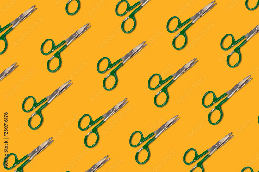 Diagonal rows of worn metal scissors on orange background Diagonal rows of worn metal scissors on orange background