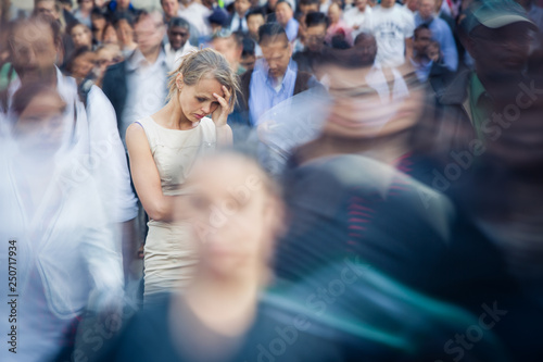 Depressed young woman feeling alone amid a crowd of people in a big city Fototapet