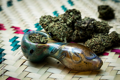 Smoking Marijuana in Pipe with Pile of Cannabis Buds