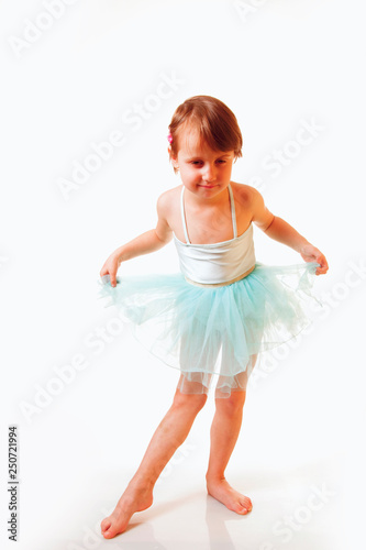 Cute little child girl in light blue dress playing in the ballet and dancing.