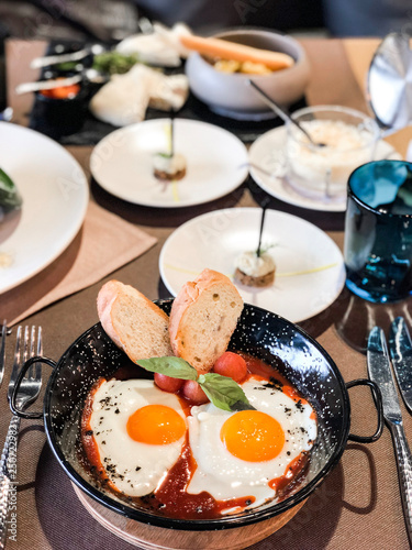 Fried eggs with baguette in an iron plate. High resolution picture perfect for cooking book, receipt book or food magazine.