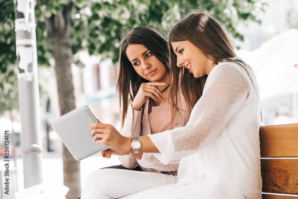 Two beautiful young women using a digital tablet Two beautiful young women using a digital tablet