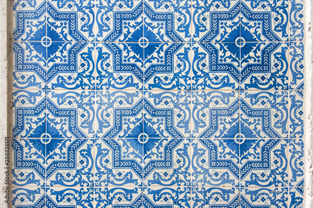 Old wall with traditional Portuguese decor tiles azulezhu in blue tones.