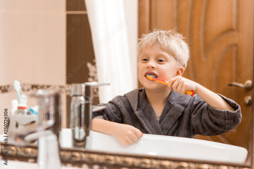 baby boy brushing his teeth and looking in the mirror.portrait of a smiling baby in Bathrobe after bathing.portrait of a smiling child with fallen milk teeth baby boy brushing his teeth and looking in the mirror.portrait of a smiling baby in Bathrobe after bathing.portrait of a smiling child with fallen milk teeth