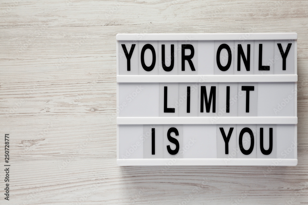 Lightbox with text 'Your only limit is you' on a white wooden background, top view. From above, flat lay, overhead. Copy space. Lightbox with text 'Your only limit is you' on a white wooden background, top view. From above, flat lay, overhead. Copy space.