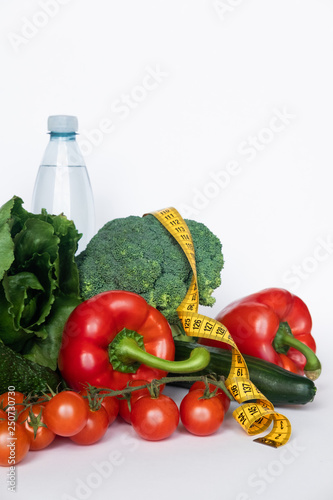 vegetables and water with tape line on white background. Healthy food concept. Copy space