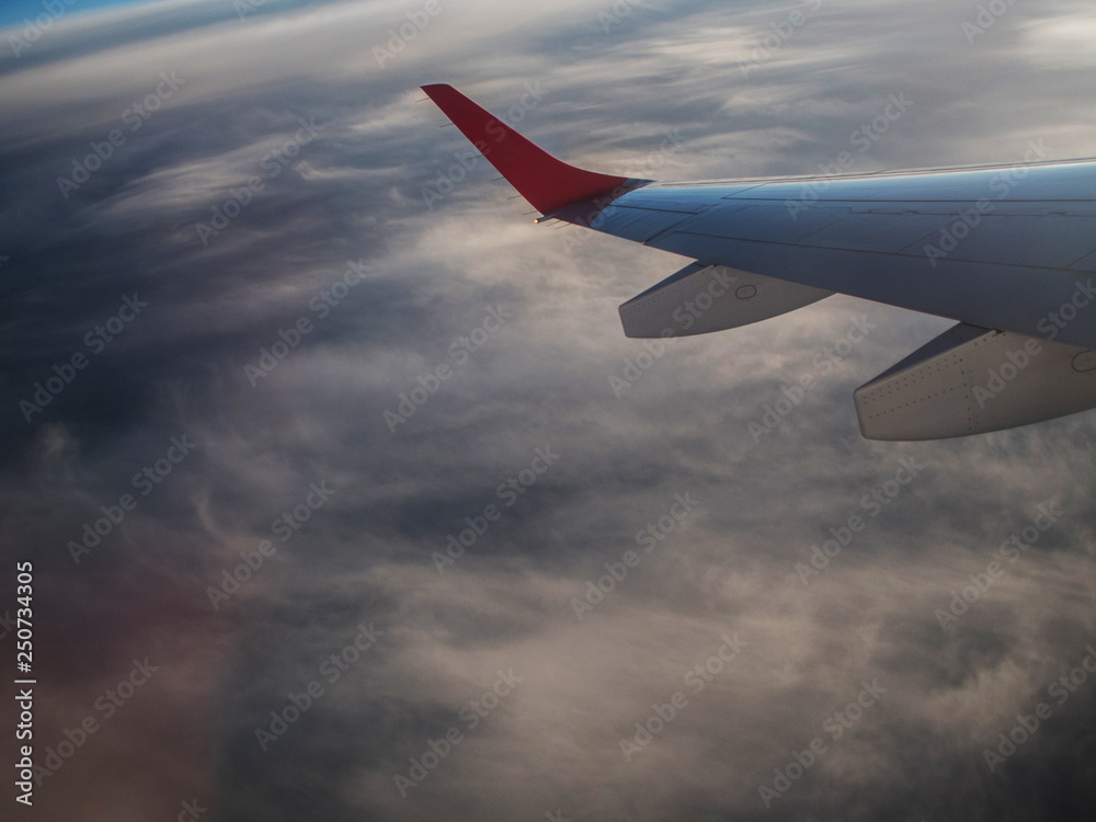 Fototapeta premium Wing of an airplane flying above the clouds.