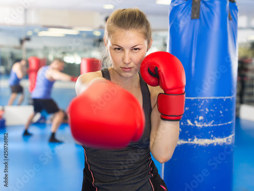 Portrait of  woman who is training in box gym. © JackF