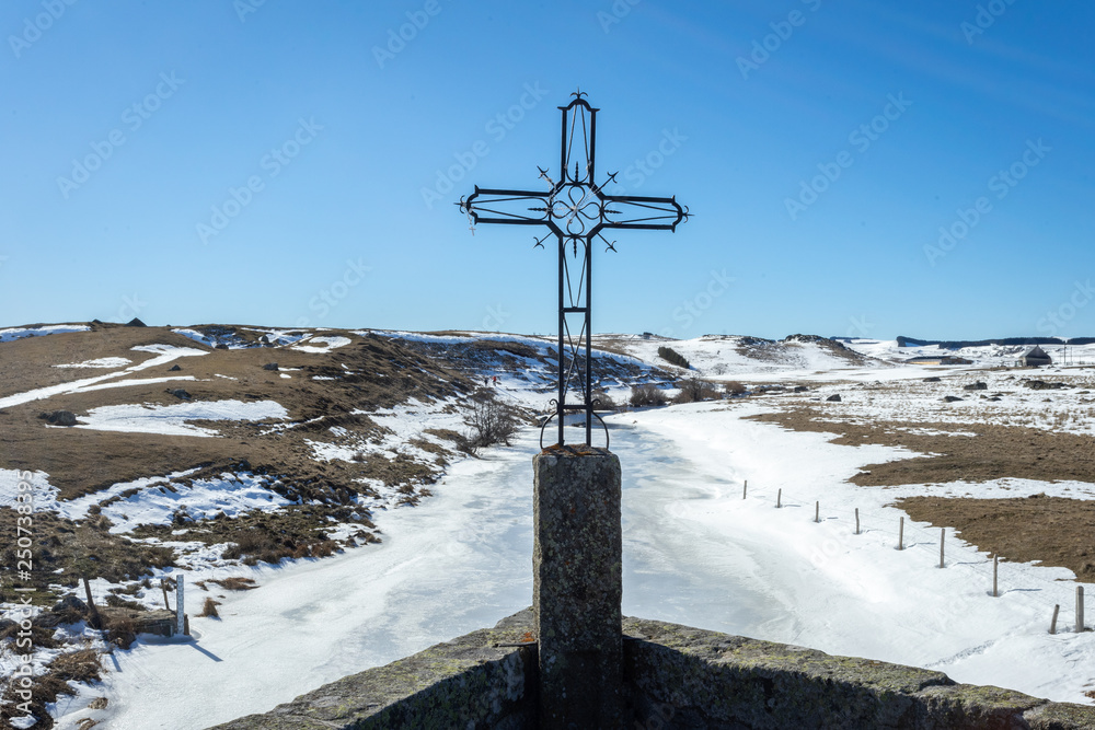 Une croix en fer forgé devant un paysage d'hiver Une croix en fer forgé devant un paysage d'hiver