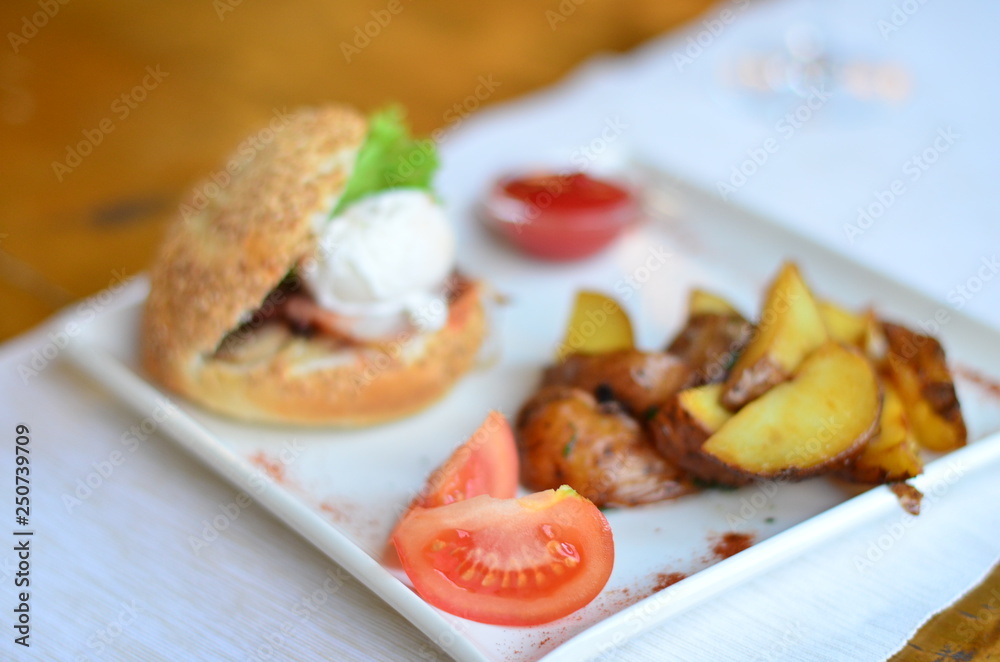 fried potatoes sliced with burger and poached egg with sauce