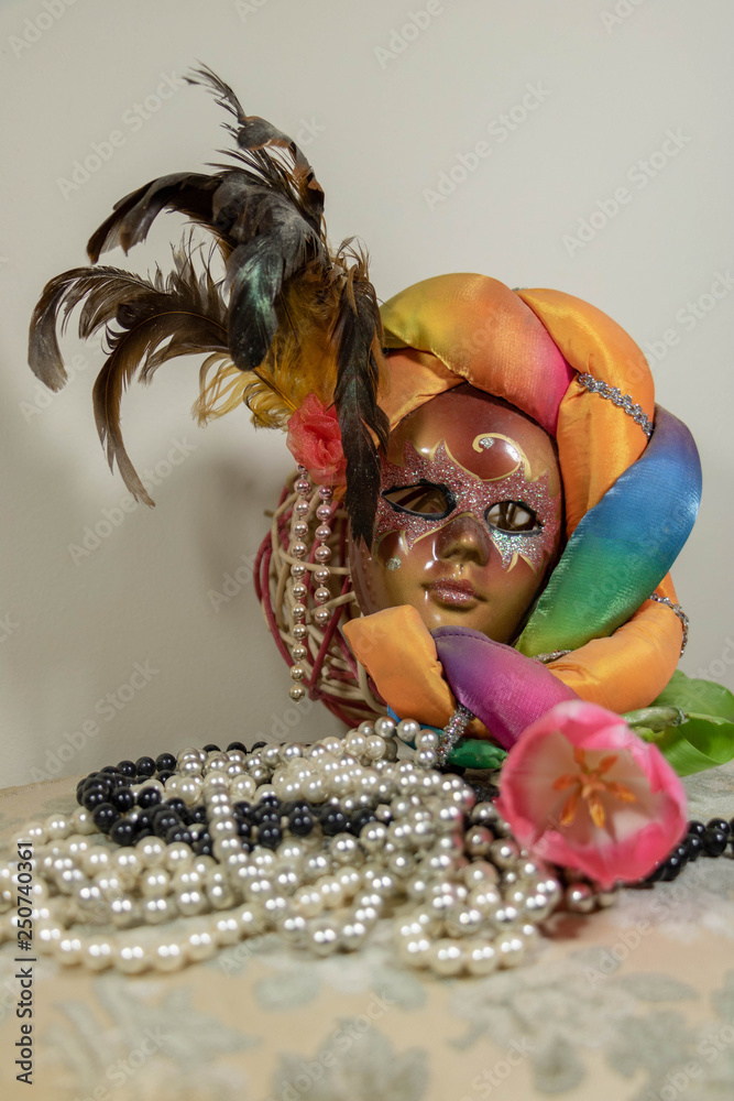 Déguisement de carnaval et fleurs de corso fleuri masque arlequin et  colliers de perles en sautoir perles blanches perles grises et perles  noires Stock Photo | Adobe Stock