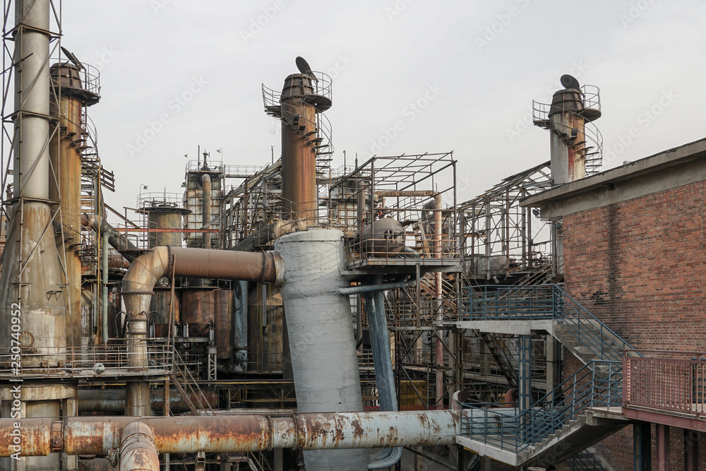 Old Factory metal structures. Industrial plant with old, rusty pipes and cooling tower for cooling water supply. Beijing, China. Old Factory metal structures. Industrial plant with old, rusty pipes and cooling tower for cooling water supply. Beijing, China.