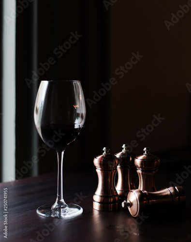 A glass of red wine and chess pieces