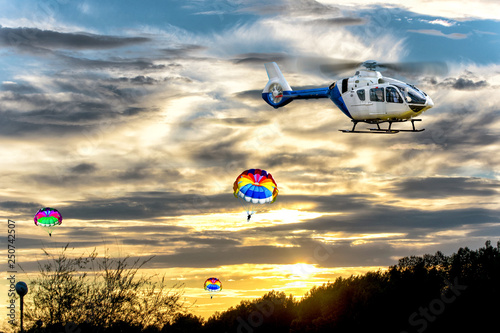 Parachutists jumping down from a helicopter in the sky. Sport and recriation. photo