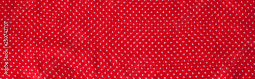 Red fabric with the white polka dots as a background texture composition