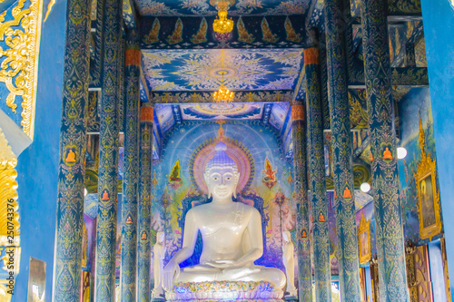 Beautiful white giant Buddha image inside the Buddhist church at Wat Rong Suea Ten Temple, also known as the Blue Temple, locate at Chiang Rai province, northern part of Thailand. photo