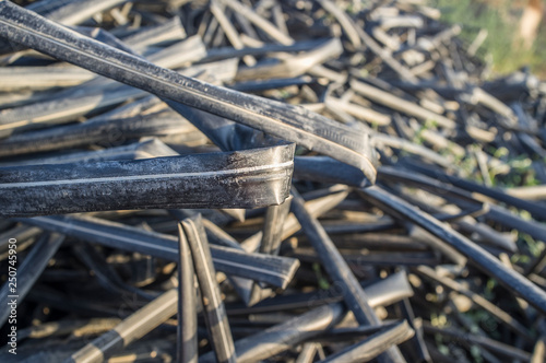 Pile of abandoned drip irrigation tapes close to cultivation field