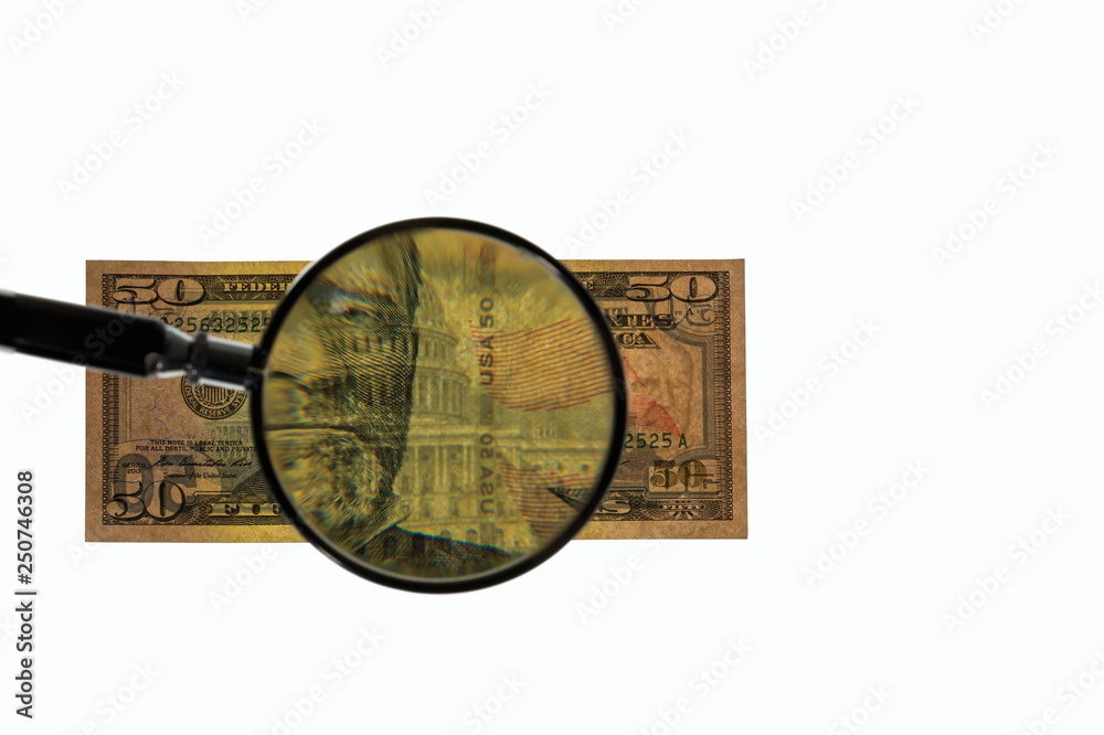 Fototapeta premium Close up view of magnifying glass over fifty dollar bill. Banknote. Beautiful backgrounds.