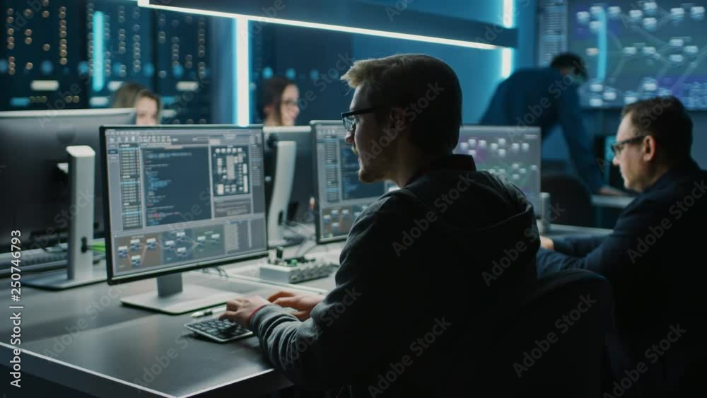 Team of IT Programers Working on Desktop Computers in Data Center Control Room. Young Professionals Writing on Sophisticated Programming Code Language