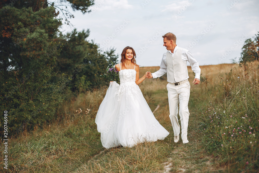 Beautiful wedding couple in a summer field