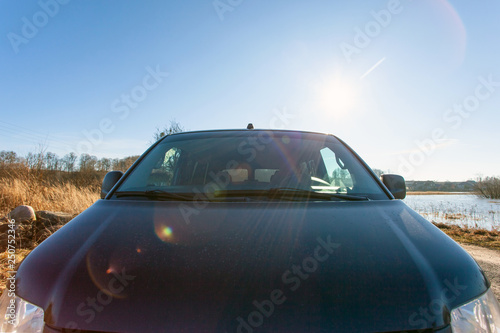 black car hood on the background of bright sunny sky